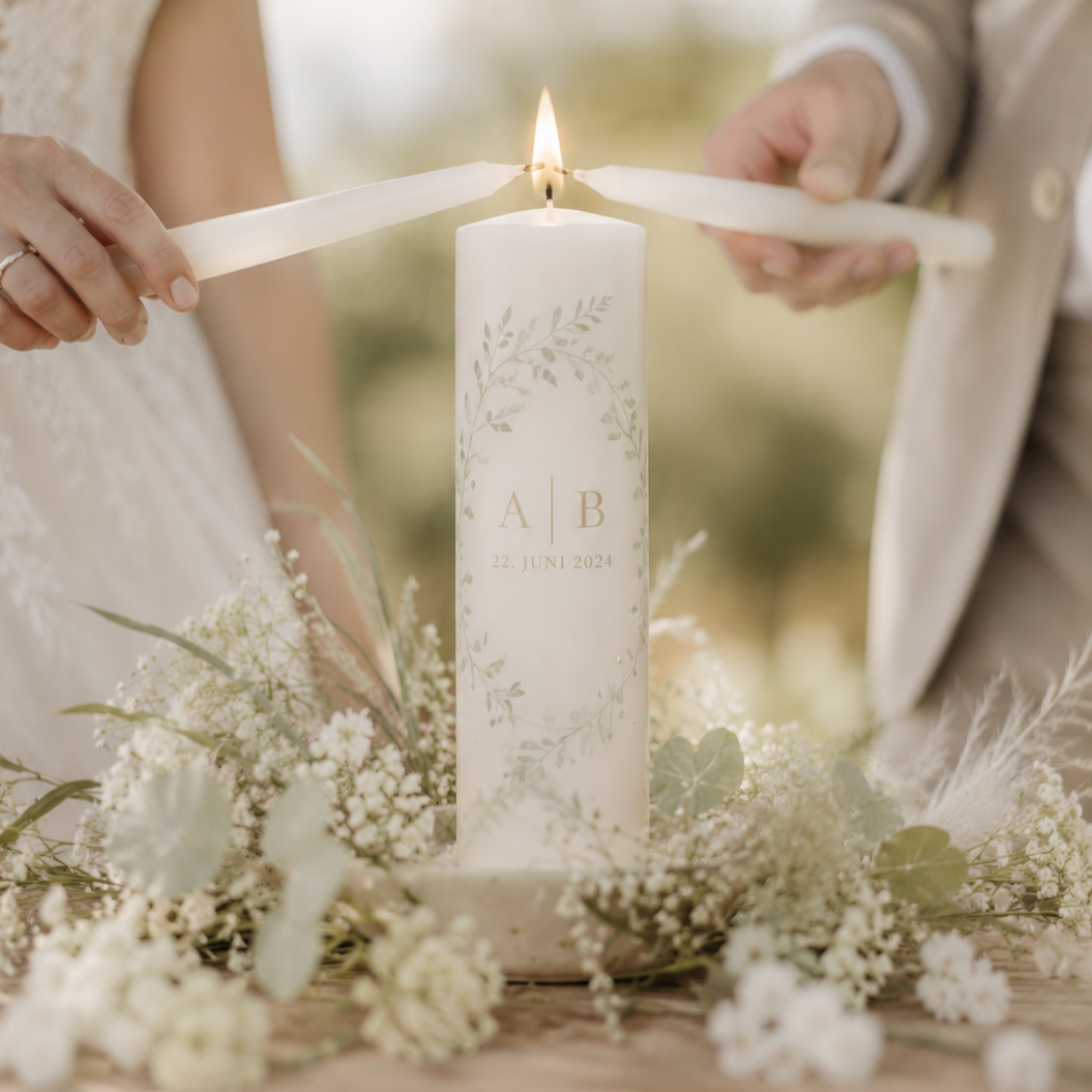 Brautpaar entzündet gemeinsam die personalisierte Hochzeitskerze mit den Initialen während der freien Trauung