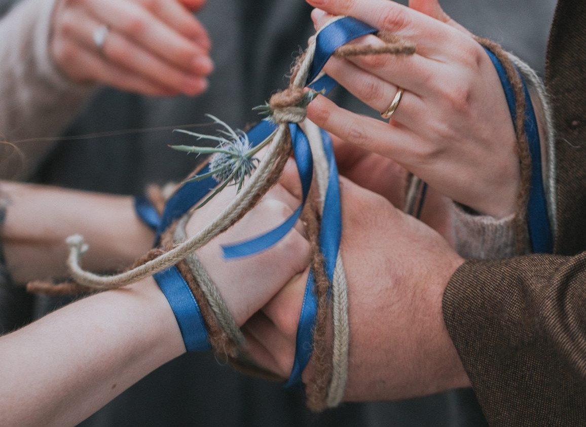 Handfasting Ritual in der freien Trauung mit verbundenen Händen und Bändern