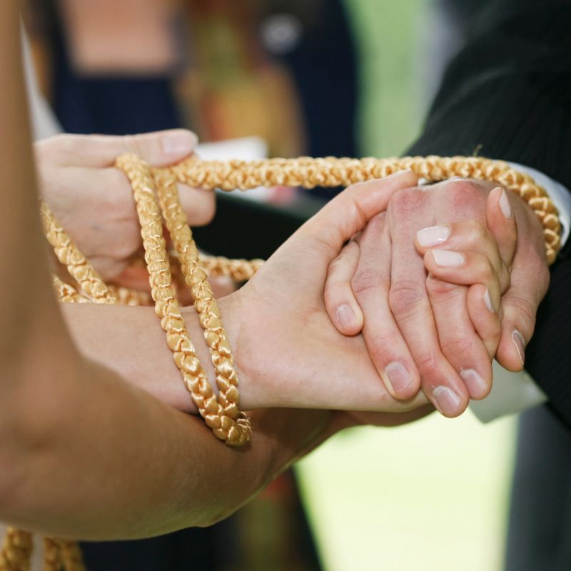 Handfasting Ritual bei einer freien Trauung, bei dem die Hände des Brautpaares mit einem Band verbunden werden