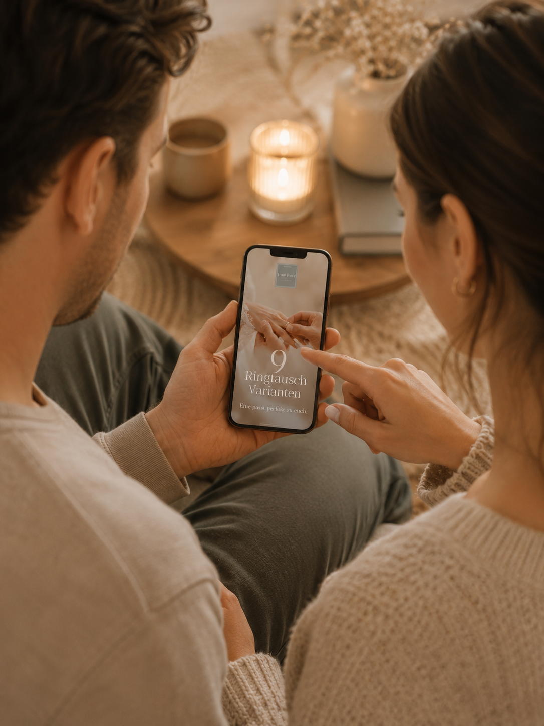 Paar sitzt zusammen und schaut auf ein Smartphone mit dem TrauWorte Ringtausch Guide
